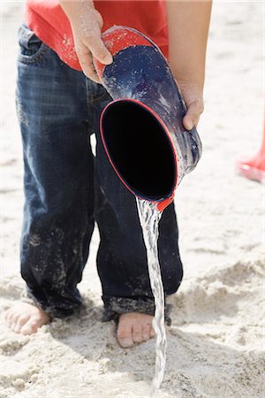 empty her wellies photography - Child pouring water out of rubber boot at the beach Stock Photo - Premium Royalty-Free, Code: 632-03652316