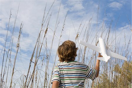 people looking up sky - Boy playing with toy airplane Stock Photo - Premium Royalty-Free, Code: 632-03652312