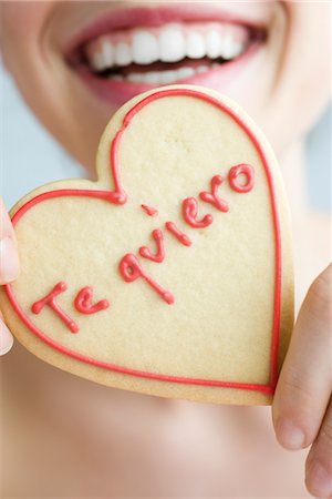 simsearch:632-03754605,k - Woman holding up heart-shaped cookie, smiling, cropped Stock Photo - Premium Royalty-Free, Code: 632-03754218