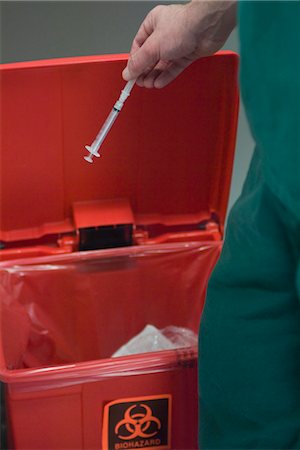 disposal - Healthcare professional placing used syringe in hazardous waste receptacle Stock Photo - Premium Royalty-Free, Code: 632-03754276