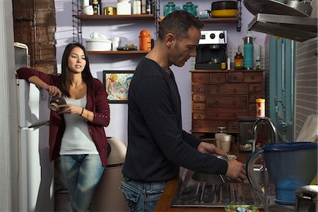 Couple in kitchen, husband doing dishes Stock Photo - Premium Royalty-Free, Code: 632-03754307