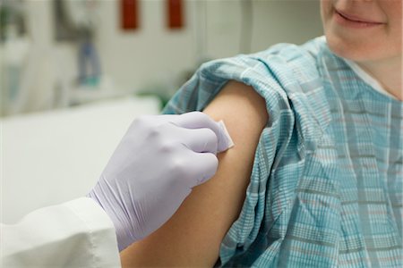 patient gown - Doctor cleaning patient's arm with alcohol swab in preparation for a shot Stock Photo - Premium Royalty-Free, Code: 632-03754355