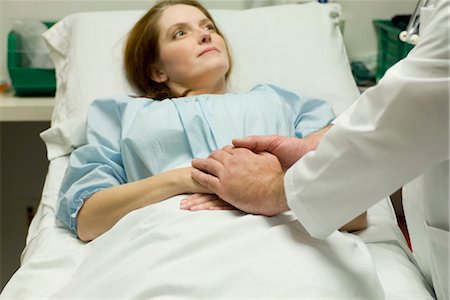 people in the hospital holding the hand of a patient - Doctor comforting patient in hospital Stock Photo - Premium Royalty-Free, Code: 632-03754370