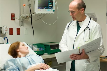 simsearch:632-03651983,k - Doctor going over chart with patient in hospital Fotografie stock - Premium Royalty-Free, Codice: 632-03754372