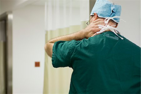 Doctor massaging neck, rear view Stock Photo - Premium Royalty-Free, Code: 632-03754386