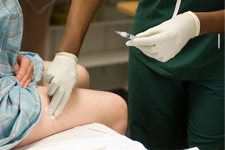 simsearch:695-05770761,k - Infirmière écouvillonnage de la jambe du patient après avoir administré un coup de feu Photographie de stock - Premium Libres de Droits, Code: 632-03754433