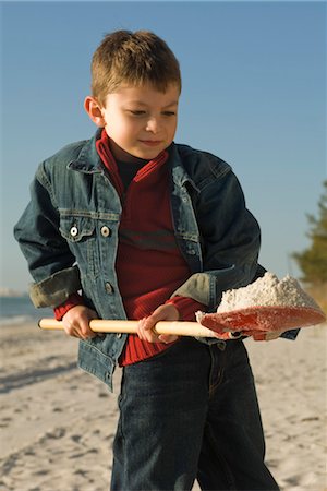 Boy digging with shovel on sandy beach Stock Photo - Premium Royalty-Free, Code: 632-03754479