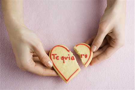Holding broken heart-shaped cookie Stock Photo - Premium Royalty-Free, Code: 632-03754637