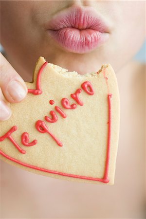 simsearch:632-03754605,k - Woman eating heart-shaped cookie, puckering lips Stock Photo - Premium Royalty-Free, Code: 632-03754659