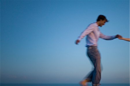 simsearch:632-03779625,k - Couple walking together along edge of infinity pool, holding hands Stock Photo - Premium Royalty-Free, Code: 632-03779401