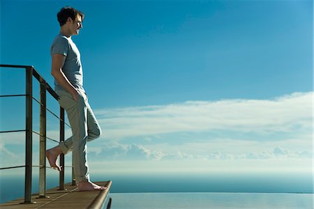 piscina desbordante - Man leaning against railing, looking at view Foto de stock - Sin royalties Premium, Código: 632-03779627