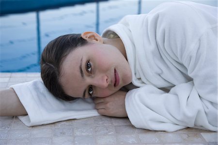 relaxing woman robe spa - Woman lying on side next to pool, portrait Stock Photo - Premium Royalty-Free, Code: 632-03779621