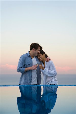 swimming pool leaning on edge - Couple embracing at edge of infinity pool, enjoying champagne Stock Photo - Premium Royalty-Free, Code: 632-03779635