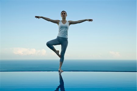 simsearch:632-05816131,k - Woman standing in tree pose on edge of infinity pool Foto de stock - Sin royalties Premium, Código: 632-03779633