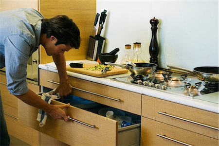 simsearch:632-03424300,k - Man cooking in kitchen, looking in drawer Foto de stock - Sin royalties Premium, Código: 632-03779748