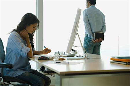 Femme travaillant au bureau à la maison, le mari regarde par la fenêtre en arrière-plan Photographie de stock - Premium Libres de Droits, Code: 632-03779774