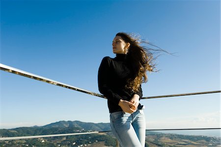 Woman leaning against railing, looking at view Stock Photo - Premium Royalty-Free, Code: 632-03847875