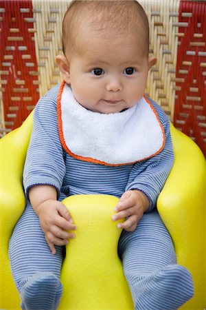 Baby sitting on booster seat, portrait Stock Photo - Premium Royalty-Free, Code: 632-03847918