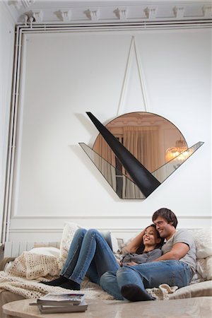 futon - Couple relaxing together, looking at digital tablet Stock Photo - Premium Royalty-Free, Code: 632-03847932