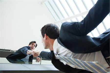 falling - Businessman leaning over balcony, holding on to colleague's hand Stock Photo - Premium Royalty-Free, Code: 632-03848096