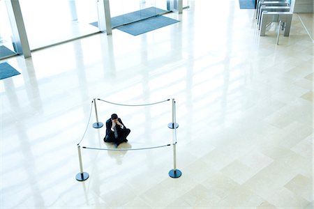 simsearch:632-03848099,k - Businessman sitting on floor inside roped off area in lobby Stock Photo - Premium Royalty-Free, Code: 632-03848105