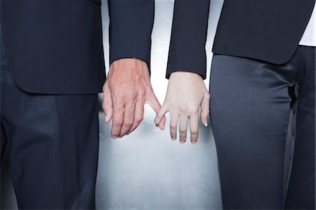 Professionals holding hands, cropped Fotografie stock - Premium Royalty-Free, Codice: 632-03848112