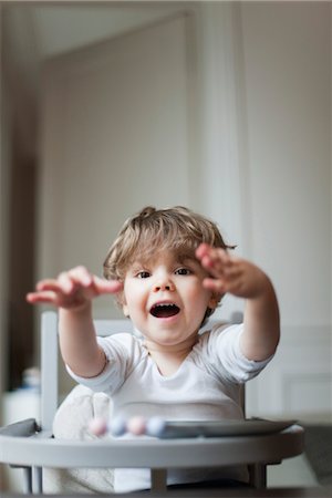 Toddler boy playing in high chair Stock Photo - Premium Royalty-Free, Code: 632-03848265