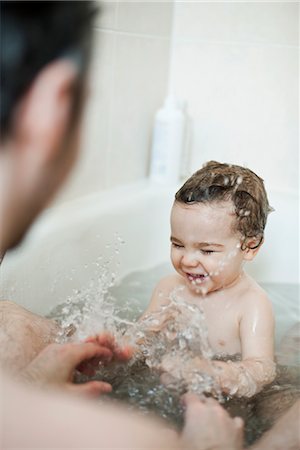 sanitário - Toddler boy splashing in bath with his father Foto de stock - Royalty Free Premium, Número: 632-03848272