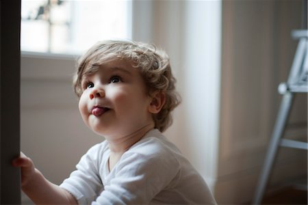 simsearch:632-03848315,k - Toddler boy sticking out tongue, looking up, portrait Foto de stock - Sin royalties Premium, Código: 632-03848299