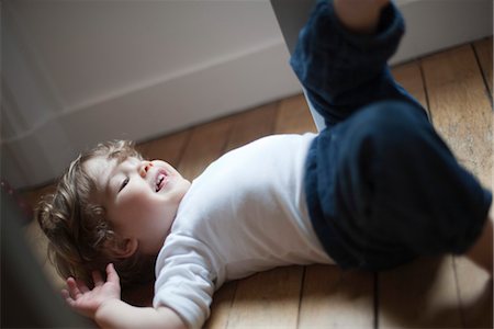 simsearch:632-03848315,k - Little boy lying on floor laughing Foto de stock - Sin royalties Premium, Código: 632-03848291