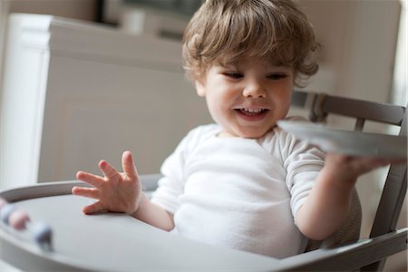 Toddler boy sitting in high chair at snacktime Stock Photo - Premium Royalty-Free, Code: 632-03848315