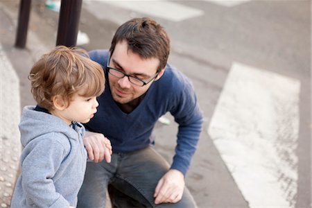 Father crouching beside toddler son, holding his hand Foto de stock - Sin royalties Premium, Código: 632-03848329