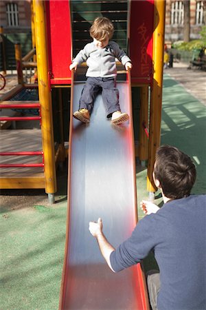 dad with kid on playground - Toddler boy preparing to go down playground slide, father waiting at the bottom Stock Photo - Premium Royalty-Free, Code: 632-03848334