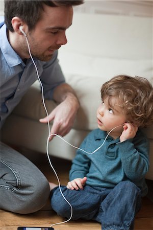 padre soltero - Father and toddler son listening to MP3 player with earphones, portrait Foto de stock - Sin royalties Premium, Código: 632-03848381