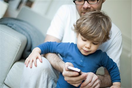 simsearch:632-03848389,k - Toddler boy watching father using cell phone Foto de stock - Royalty Free Premium, Número: 632-03848403