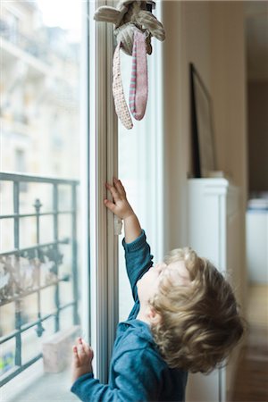 Toddler boy reaching for toy Foto de stock - Sin royalties Premium, Código: 632-03848419