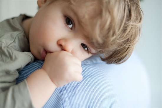 Toddler boy resting head on parent's shoulder, tears on face Stock Photo - Premium Royalty-Free, Image code: 632-03848431