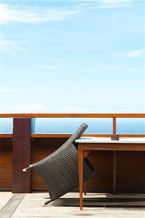 simsearch:632-02745314,k - Wicker chair leaning against table on deck Foto de stock - Sin royalties Premium, Código: 632-03897773