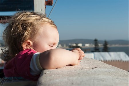 Toddler girl leaning against side of balcony with eyes closed Stock Photo - Premium Royalty-Free, Code: 632-03897780