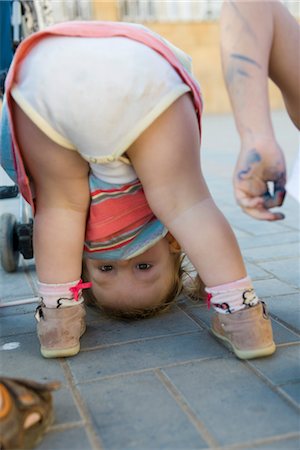 simsearch:632-03897850,k - Toddler girl bending over, peeking through legs at camera Stock Photo - Premium Royalty-Free, Code: 632-03897850