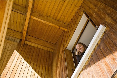 Woman looking out window, looking down at camera Stock Photo - Premium Royalty-Free, Code: 632-03897936