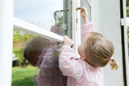 Fille d'enfant en bas âge atteignant pour ouvrir la porte Photographie de stock - Premium Libres de Droits, Code: 632-03898075