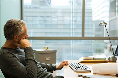 desktop pc - Man sitting at desk in office, looking away in thought Stock Photo - Premium Royalty-Free, Code: 632-03898161