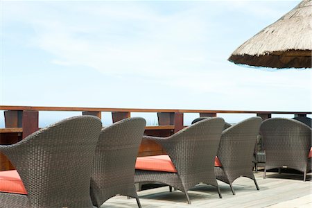 simsearch:632-03779378,k - Wicker chairs lined up along deck Stock Photo - Premium Royalty-Free, Code: 632-03898178