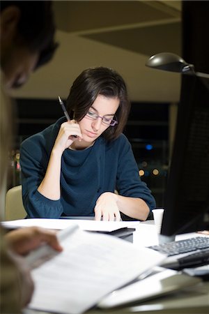 Colleagues reading documents in office at night Stock Photo - Premium Royalty-Free, Code: 632-03898368