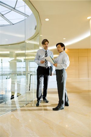 Unternehmer diskutieren Dokument im Korridor Stockbilder - Premium RF Lizenzfrei, Bildnummer: 632-03898376