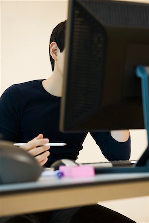 simsearch:632-03847673,k - Office worker sitting at desk with computer Foto de stock - Sin royalties Premium, Código: 632-03898371