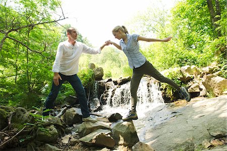 Couple standing on rocks by waterfall Foto de stock - Sin royalties Premium, Código: 633-05401327