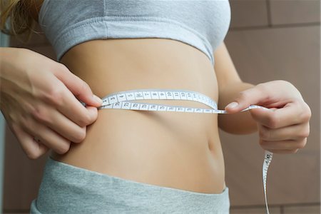 Woman measuring her waist with measuring tape, cropped Foto de stock - Sin royalties Premium, Código: 633-05401336