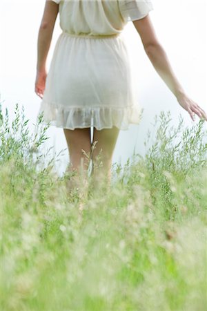 Jeune femme marchant dans les herbes hautes, recadrée Photographie de stock - Premium Libres de Droits, Code: 633-05401347